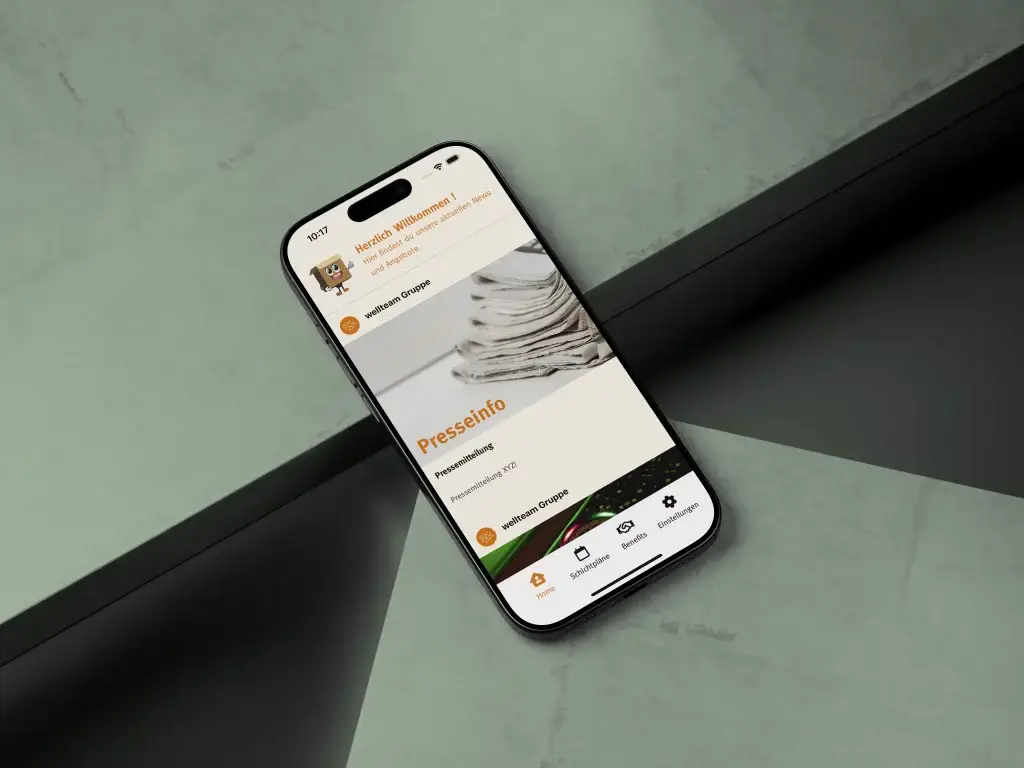 Smartphone mit geöffneter Unternehmens App, die aktuelle Presseinformationen und Neuigkeiten anzeigt, auf einem modernen, grünen Hintergrund platziert.