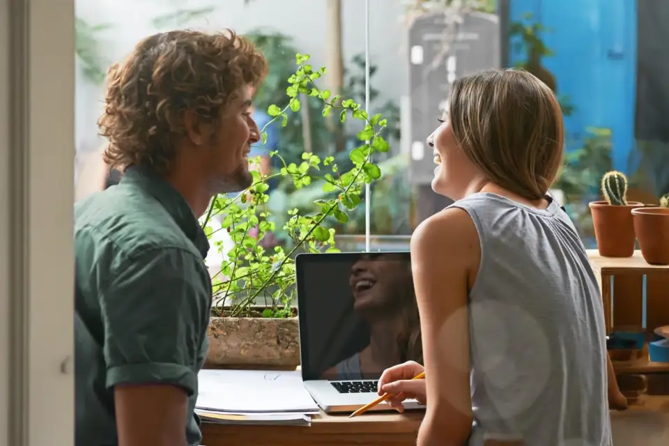 Zwei Personen arbeiten gemeinsam am Laptop und diskutieren über aktuelle IT Trends – Snutig, Ihre Agentur für digitale Lösungen.